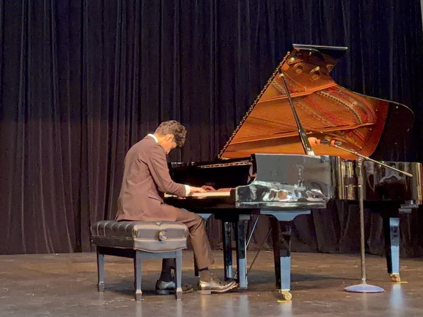 Omkar Abhyankar performing at a grand piano on stage
